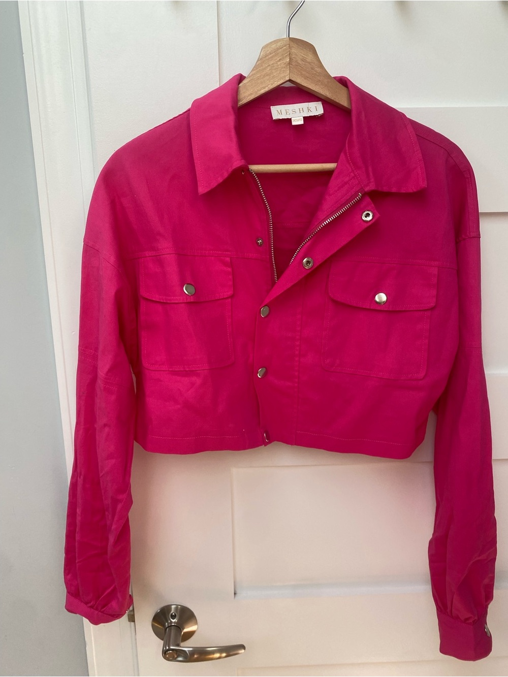 Meshki hot pink crop jacket featuring a zip-up closure and silver button details